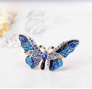 Close-up of butterfly brooch with blue enamel wings and sparkling rhinestones
