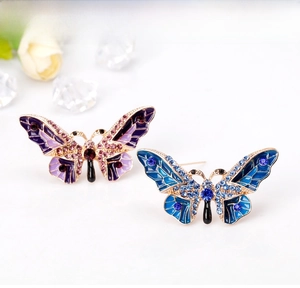 Detail of colorful enamel butterfly brooches with shimmering rhinestones and gold plating