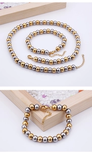Dettaglio di collana e bracciale con perle bicolore oro e argento con chiusura a moschettone