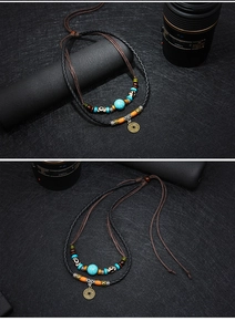 Detail van de vintage munt hanger met turquoise kralen aan een dubbele gevlochten ketting