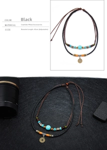 Detail van gevlochten leren ketting met turkooizen kralen en bronzen munt hanger