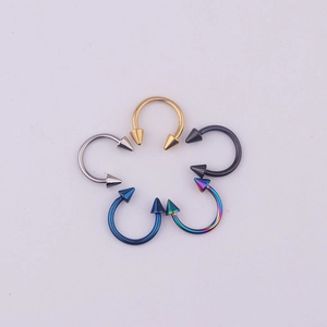 Five 316L stainless steel circular barbells with spikes in gold, silver, black, blue, and rainbow