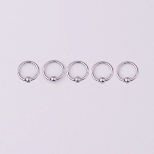 Detailed view of five 316L stainless steel seamless captive bead rings for piercings