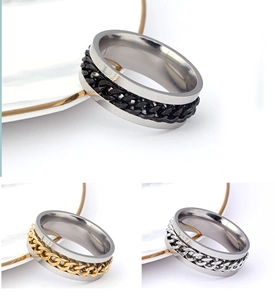 Detail of rotating chain mechanism on stainless steel rings in black gold and silver