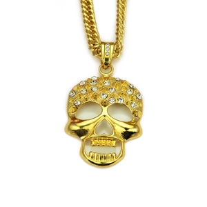 Makroaufnahme eines goldenen Totenkopf-Anhängers mit Kristallen an einer Panzerkette