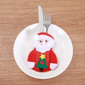 Detail of Santa Claus felt cutlery holder with Christmas tree motif on wooden table