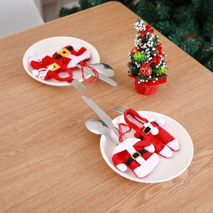 Miniature Christmas sweater and pants cutlery holders placed on a white plate