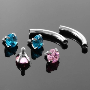 Detailed macro of stainless steel curved piercing bars with pink and blue zircon gems