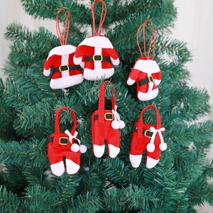 Close-up of mini knitted Christmas sweater and pants cutlery holders on tree branches