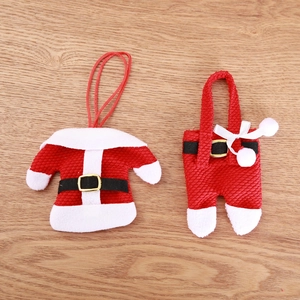 Christmas miniature red clothing cutlery holder set on a light wood tabletop background