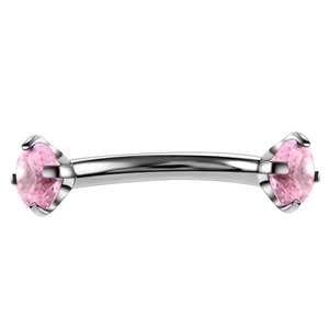 Detail of pink zircon curved barbell piercing with four-prong silver stainless steel setting