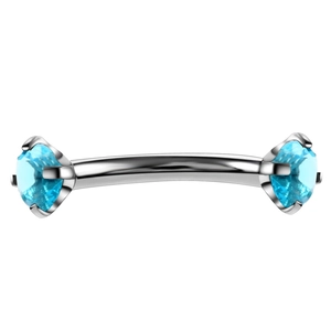 Macro view of blue zircon curved barbell eyebrow ring with silver stainless steel prongs