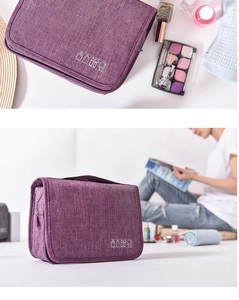 Detailed view of a purple hanging toiletry bag with travel accessories on a white surface