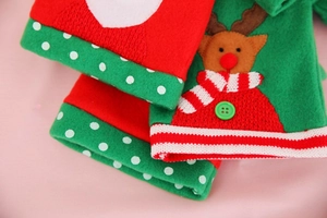 Detail of Christmas wine bottle cover featuring embroidered Santa and reindeer designs