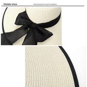 Dettaglio della trama in paglia e del fiocco nero in seta del cappello da sole