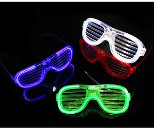 Four LED shutter glasses glowing in blue white red and green colors on black background