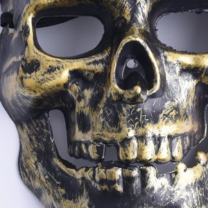 Macro shot of skull mask showing textured eye sockets and distressed gold and black finish