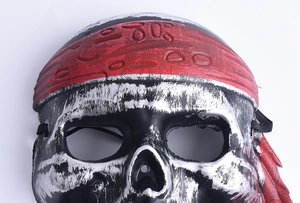 Detail of vintage skull pirate mask featuring silver metallic finish and red textured bandana