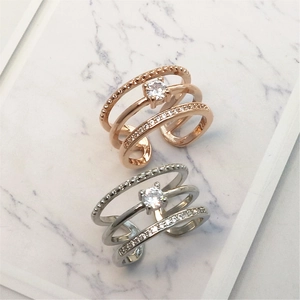 Detail of three-layer adjustable rings with cubic zirconia on marble background