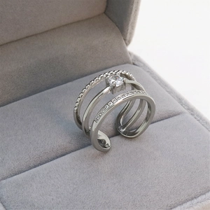 Close-up of silver triple-layer adjustable ring with clear crystals in a gray velvet box