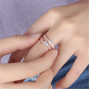 Close-up of rose gold triple-layered ring with crystals on a female finger