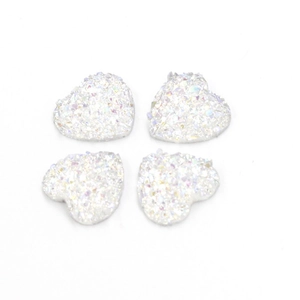 Macro-opname van vier witte iriserende hartvormige harsstenen met glitter kristaltextuur