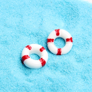 Marine resin lifesaver charms for DIY phone cases featuring nautical red stripes on blue sand