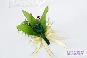 Detail of the back view of the orchid boutonniere featuring a green plastic safety pin clip