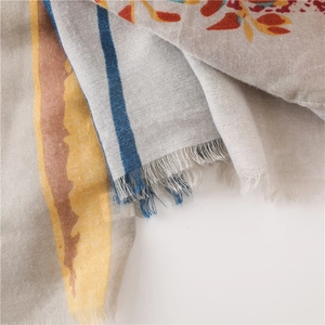Detail view of cotton linen scarf with floral print, stripes and fringe edges