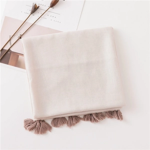 Close-up of soft pink linen blend scarf with elegant tassel fringe and textured weave