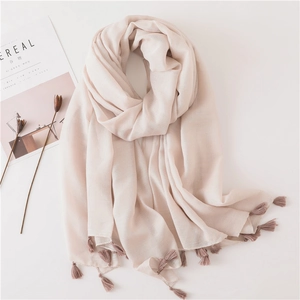 Detail of light pink linen scarf with delicate fringe tassels and woven texture