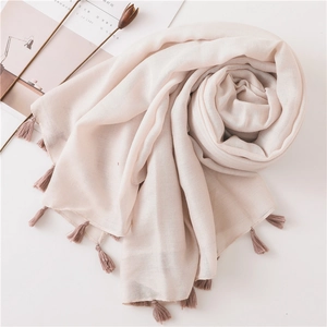 Close-up of light pink cotton linen scarf featuring delicate handmade tassel fringes