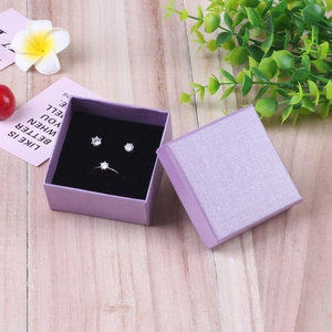 Elegant purple linen jewelry gift box set with ring and earrings on wood background