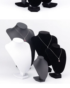 Multiple sizes of black velvet and white leather necklace display busts for jewelry
