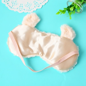 Plush pink animal-shaped sleeping eye mask with soft satin lining on blue background