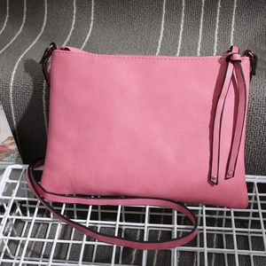 Pink PU leather envelope bag featuring side tassel detail and matching long shoulder strap