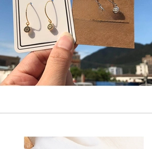 Detailed view of evil eye dangle earrings with sparkling rhinestones and gold hooks