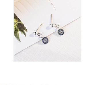 Macro shot of silver stud earrings with blue and white pavé cubic zirconia devil eye