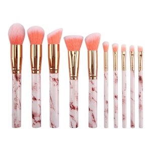 Detail of 10-piece portable marble makeup brush set with pink bristles and gold ferrule
