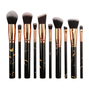 Detail of 10-piece makeup brush set featuring black marble handles and rose gold ferrules