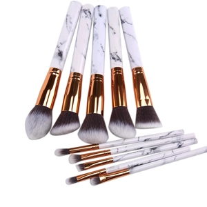 Detail of 10-piece marble makeup brush set with rose gold metal ferrules on white background