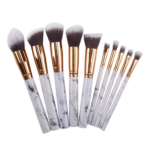 Detail of 10-piece marble makeup brush set with rose gold ferrules on white background
