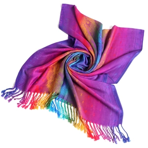 Detailed spiral fold of rainbow ethnic shawl with jacquard peacock feather and fringe
