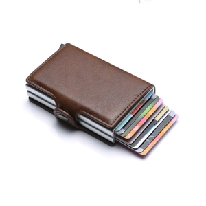 Detailed macro view of brown leather and silver aluminum pop-up card wallet in use