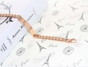 Detailed close-up of rose gold Cuban link ID bracelet with polished metal bar