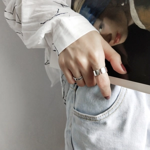 Detail of silver chain ring and wide open band on hand for a modern minimalist style