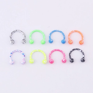 Detail view of eight colorful paint-splattered horseshoe rings with round beads