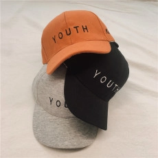 Close-up of stacked PU leather baseball caps in orange, black and gray with YOUTH embroidery