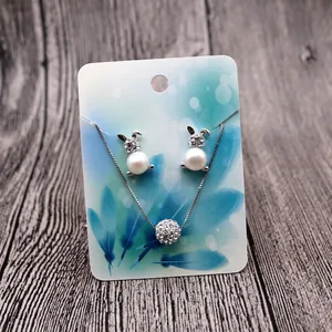 Detail of silver bunny jewelry set with pearls and rhinestones on display card