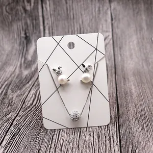 Silver bunny pearl earrings and disco ball pendant necklace set on display card